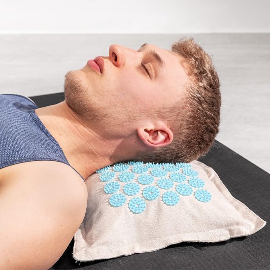 tête d'homme coucher sur l'oreiller du tapis acupression