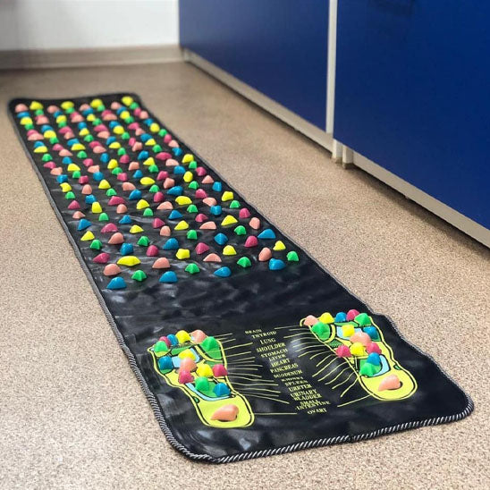 tapis d acupression avec pierre muticolore poser sur le plancher